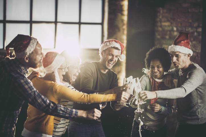 Joyful business team having fun while opening champagne during Christmas celebration in the office. Joyful business team having fun while opening champagne during Christmas celebration in the office.