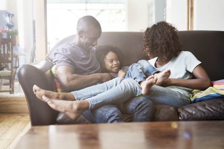 Cheerful family sitting on sofa at home