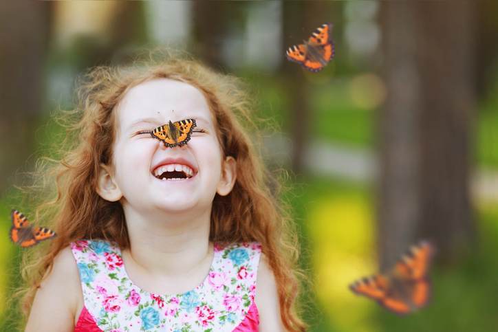 Surprised curly girl with a butterfly on his nose. Surprised curly girl with a butterfly on his nose.