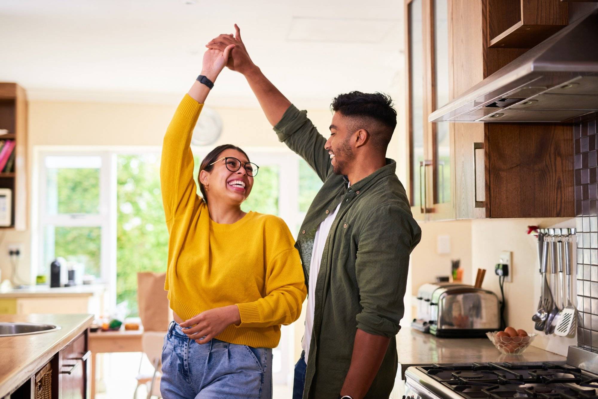 Shot of a young couple dancing together in their kitchen