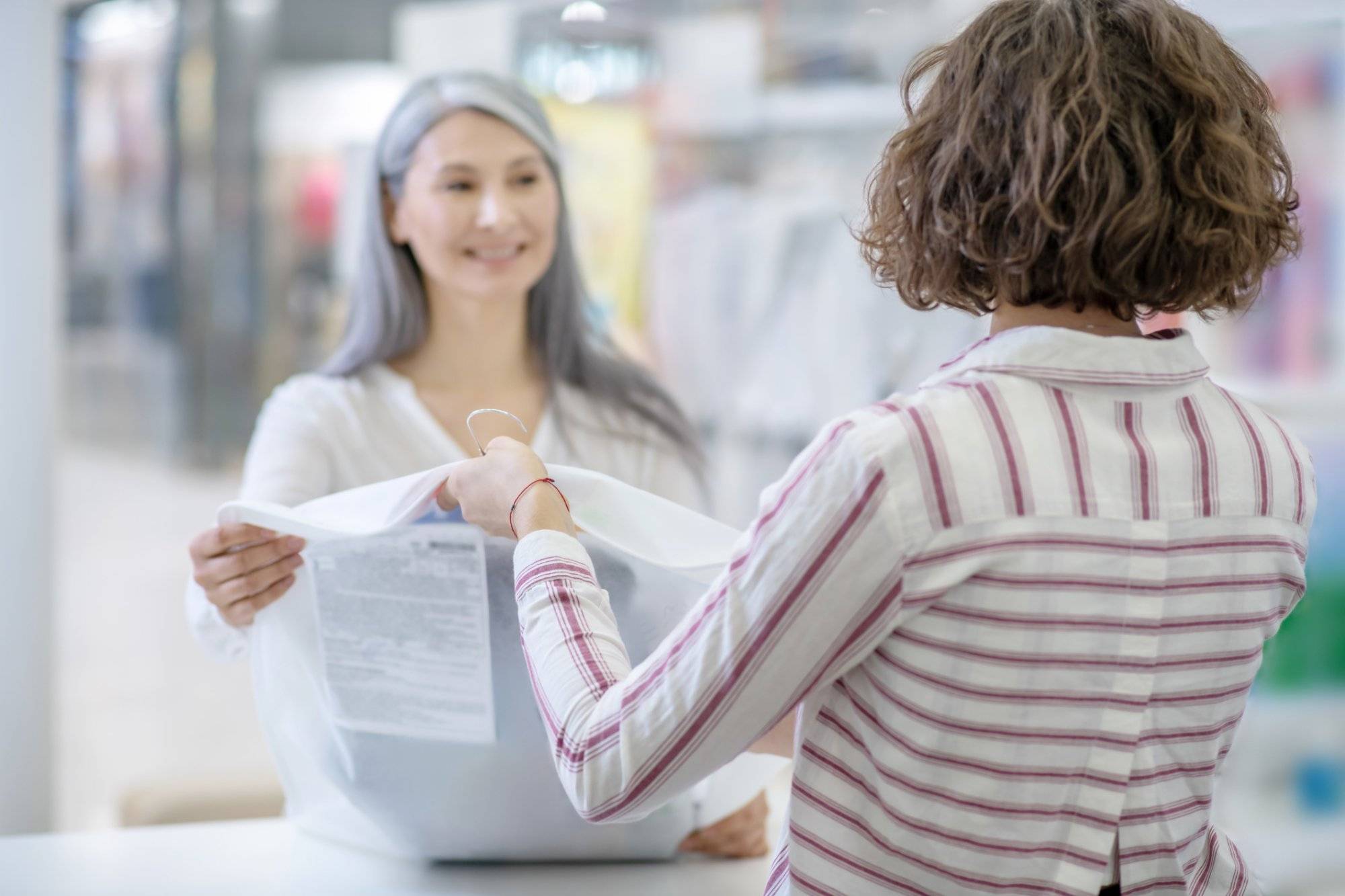 Woman with back to camera giving order to customer Woman with back to camera giving order to customer
